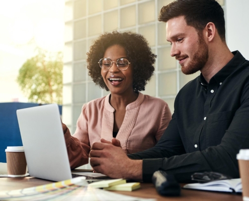 Two people working at laptop